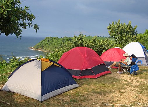 Homem acampando em uma região montanhosa.